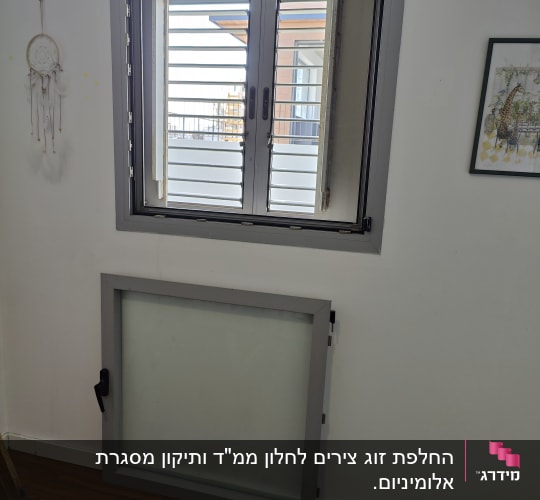 תריסים אפורים על חלון עם מסגרת מתכת